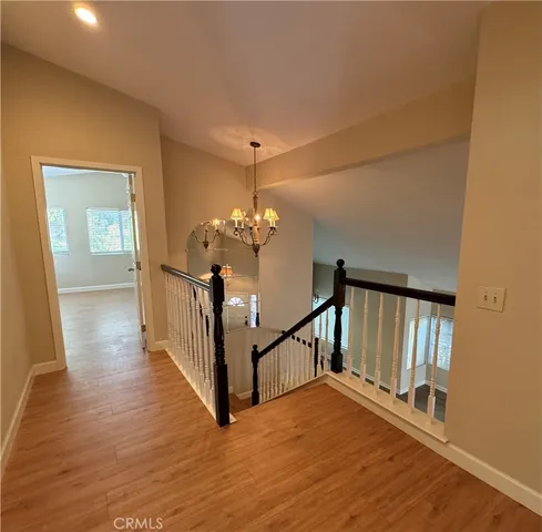 a view of a hallway with wooden floor and staircase