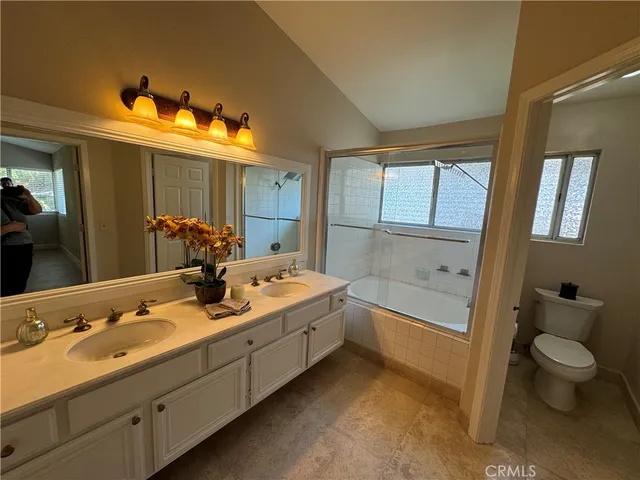 a bathroom with a tub sink toilet and mirror