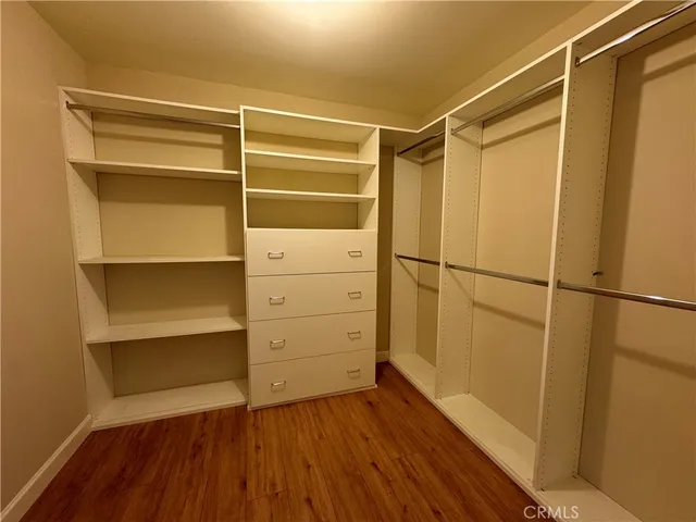 a view of walk in closet with empty racks