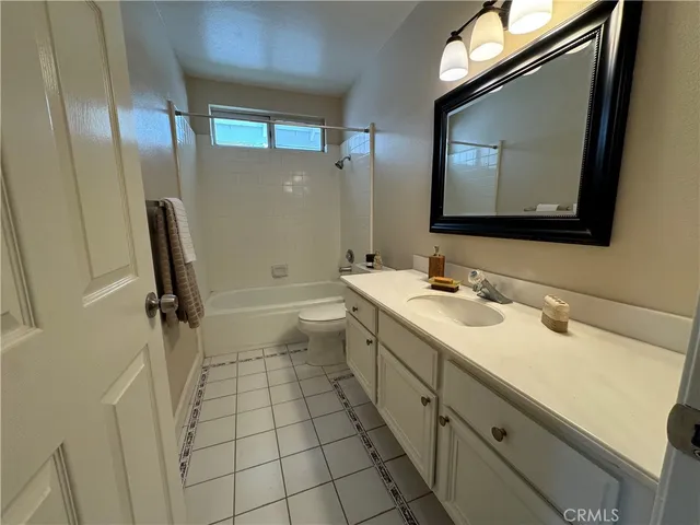 a bathroom with a double vanity sink mirror and bathtub
