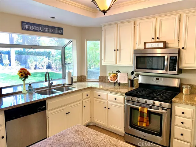 a kitchen with stainless steel appliances a stove sink and microwave