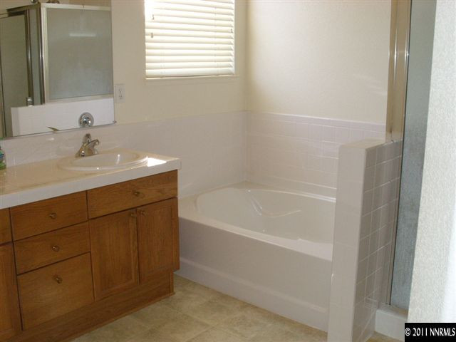1765 Canyonlands Way Reno, NV 89521 - Photo 10 of 12 a bathroom with a bathtub sink vanity and a mirror