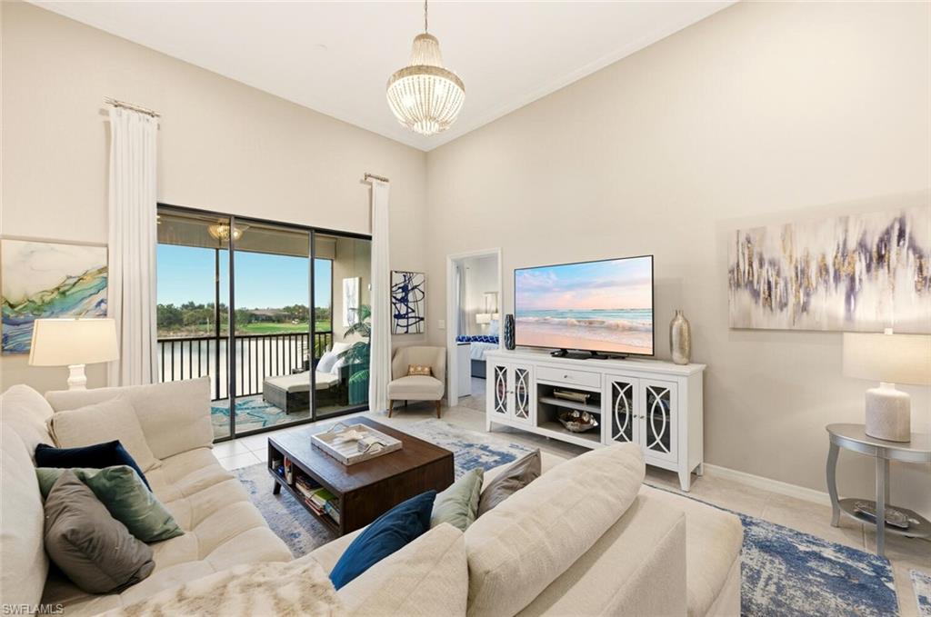 9365 Pocida Court, Unit 202 Naples, FL 34119 - Photo 12 of 40 a living room with furniture a flat screen tv and a large window