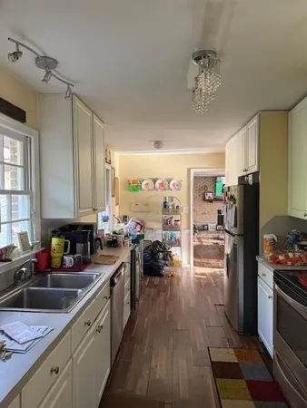 a kitchen with a sink appliances cabinets and a counter space