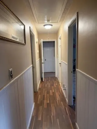 a view of a hallway with wooden floor and staircase
