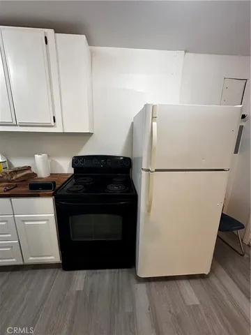 a utility room with wooden floor and cabinets