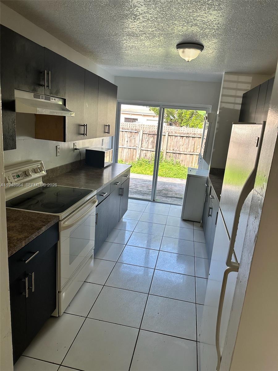 13993 Southwest 280th Terrace Homestead, FL 33033 - Photo 19 of 22 a kitchen with stainless steel appliances granite countertop a sink stove and cabinets