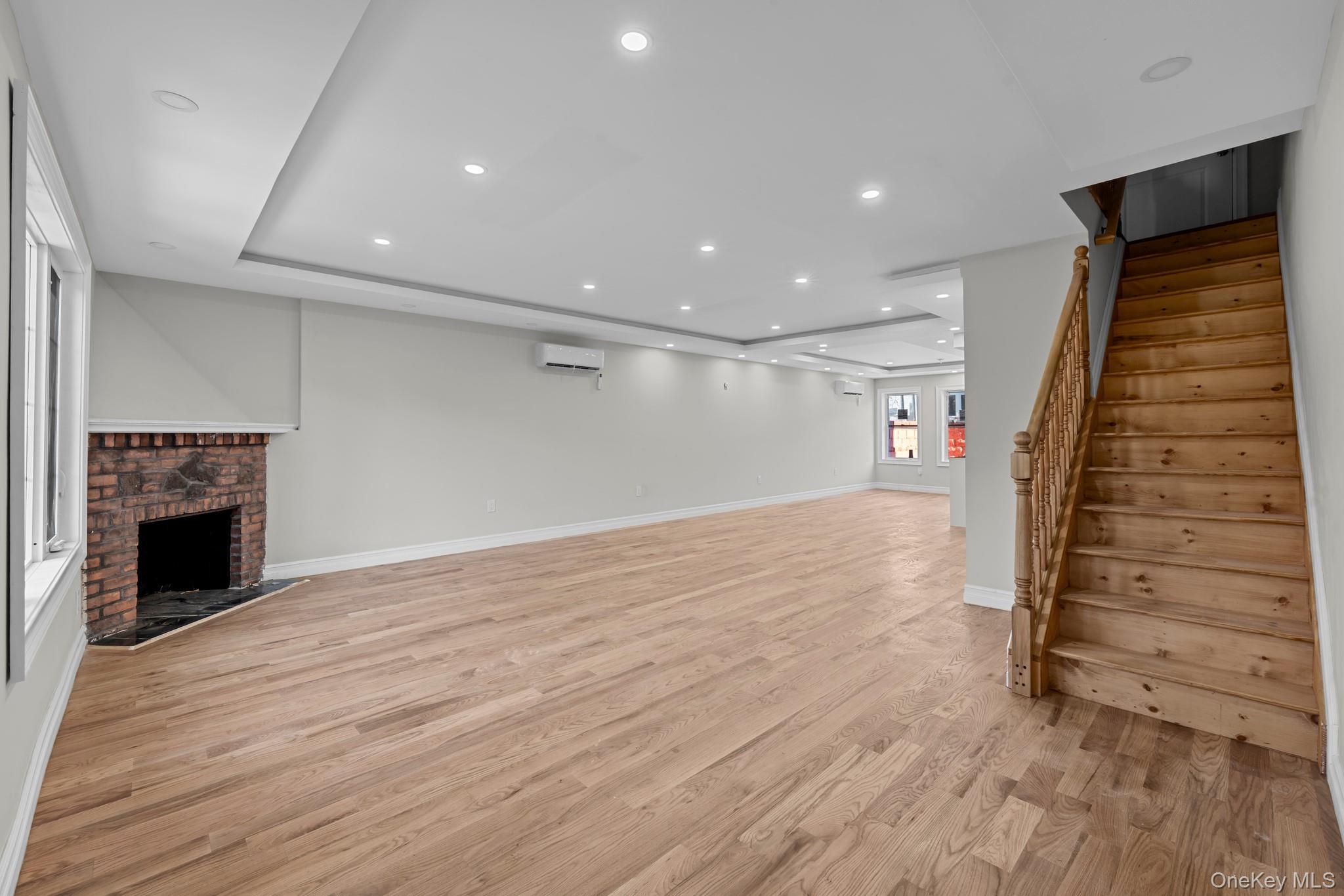 179-18 Selover Road Queens, NY 11434 - Photo 5 of 18 Basement with a brick fireplace, stairway, recessed lighting, and light wood finished floors