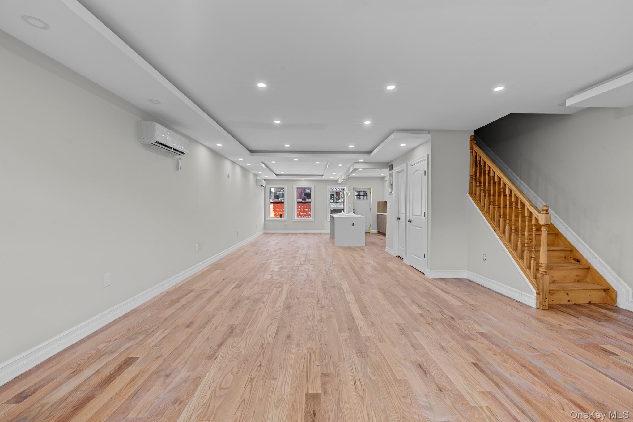 179-18 Selover Road Queens, NY 11434 - Photo 7 of 18 Unfurnished living room with light wood-style floors, recessed lighting, stairway, and a raised ceiling