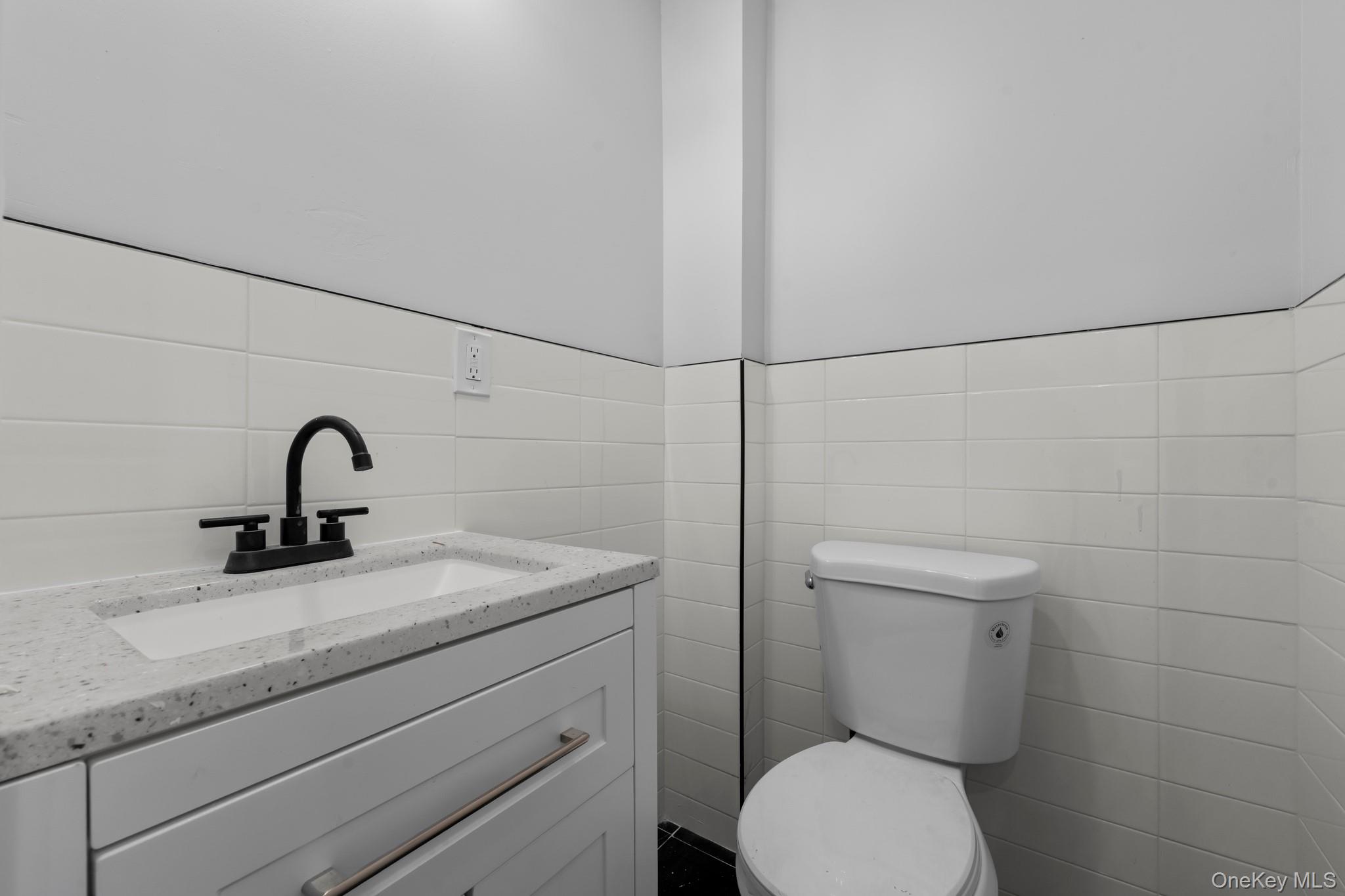 179-18 Selover Road Queens, NY 11434 - Photo 8 of 18 Half bathroom featuring vanity and tile walls