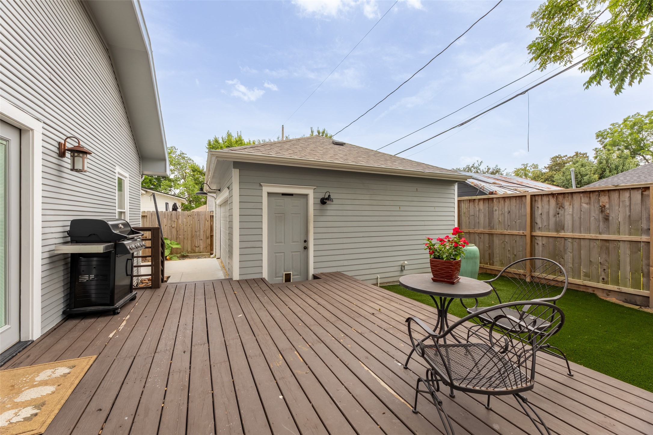 1120 Winston Street Houston, TX 77009 - Photo 8 of 32 The spacious deck extends to the garage, creating an ideal outdoor living area with a charming water fountain, room for a garden, and the cooling shade of a beautiful mature trees