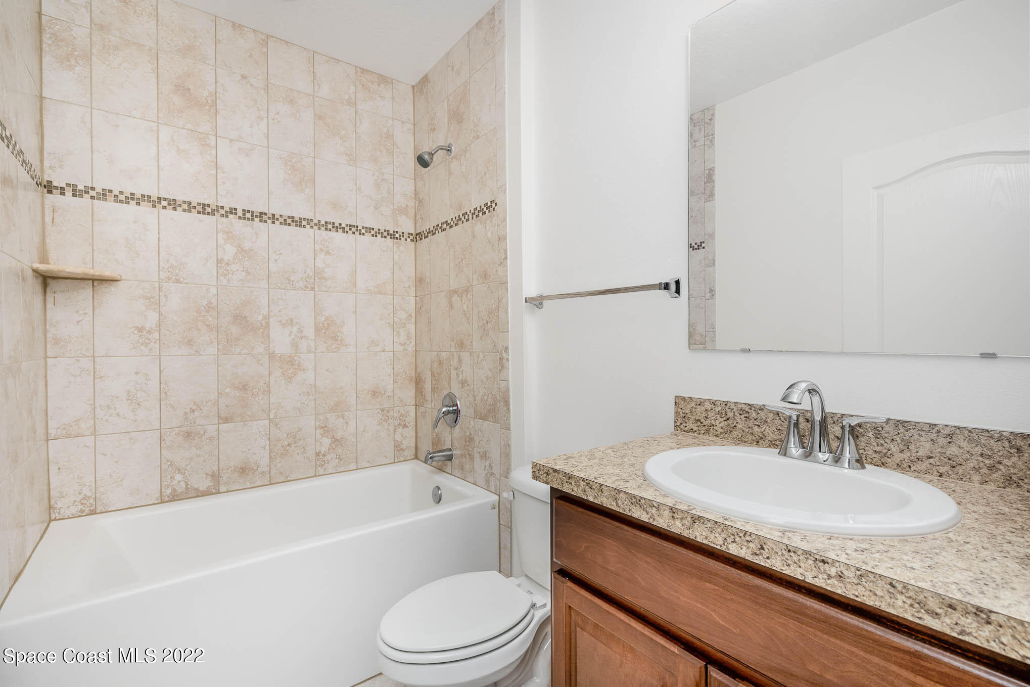 1061 Wabash Road Southeast Palm Bay, FL 32909 - Photo 13 of 22 a bathroom with a granite countertop sink toilet and shower