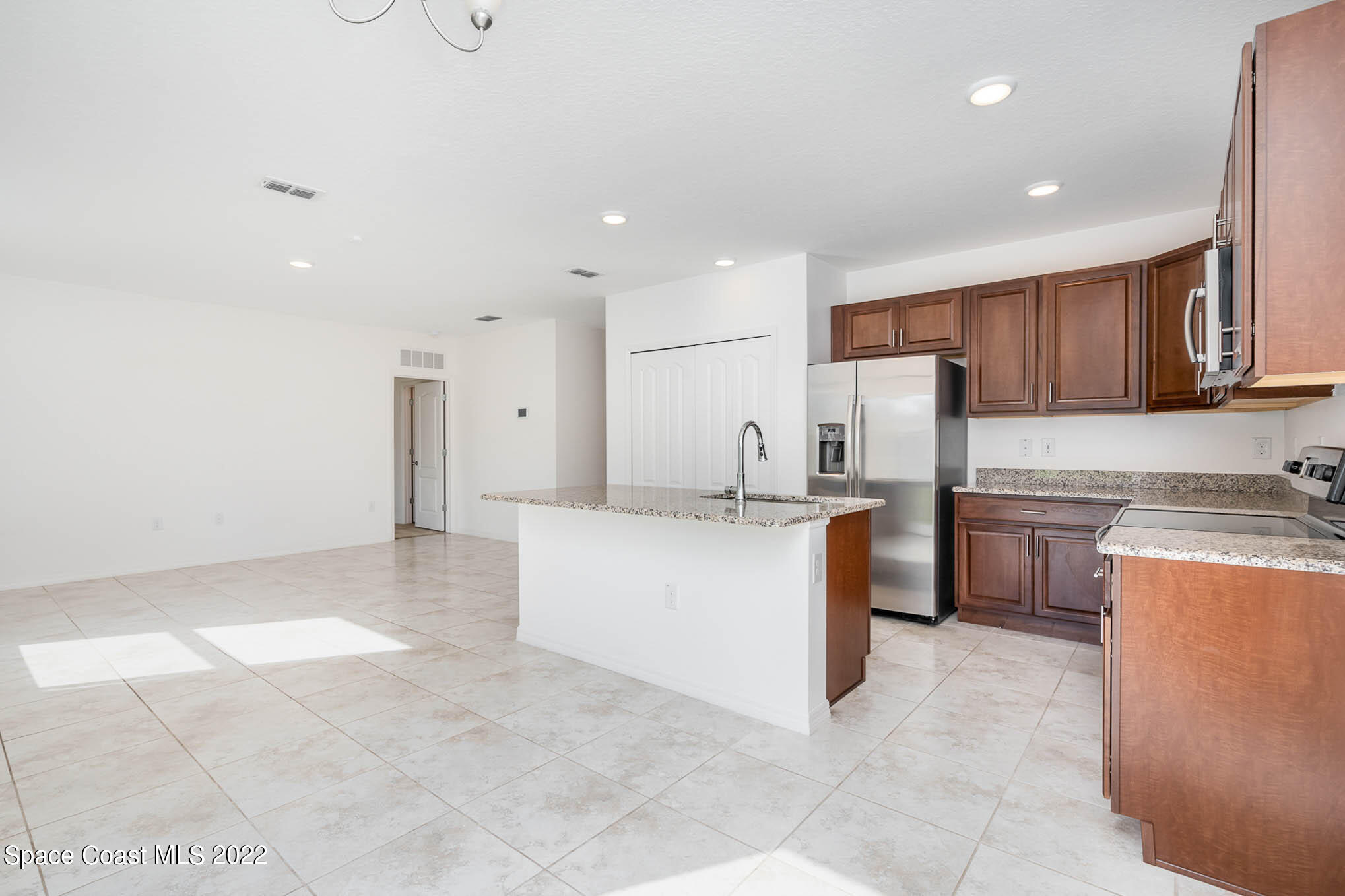 1061 Wabash Road Southeast Palm Bay, FL 32909 - Photo 5 of 22 a kitchen with a refrigerator and a stove top oven