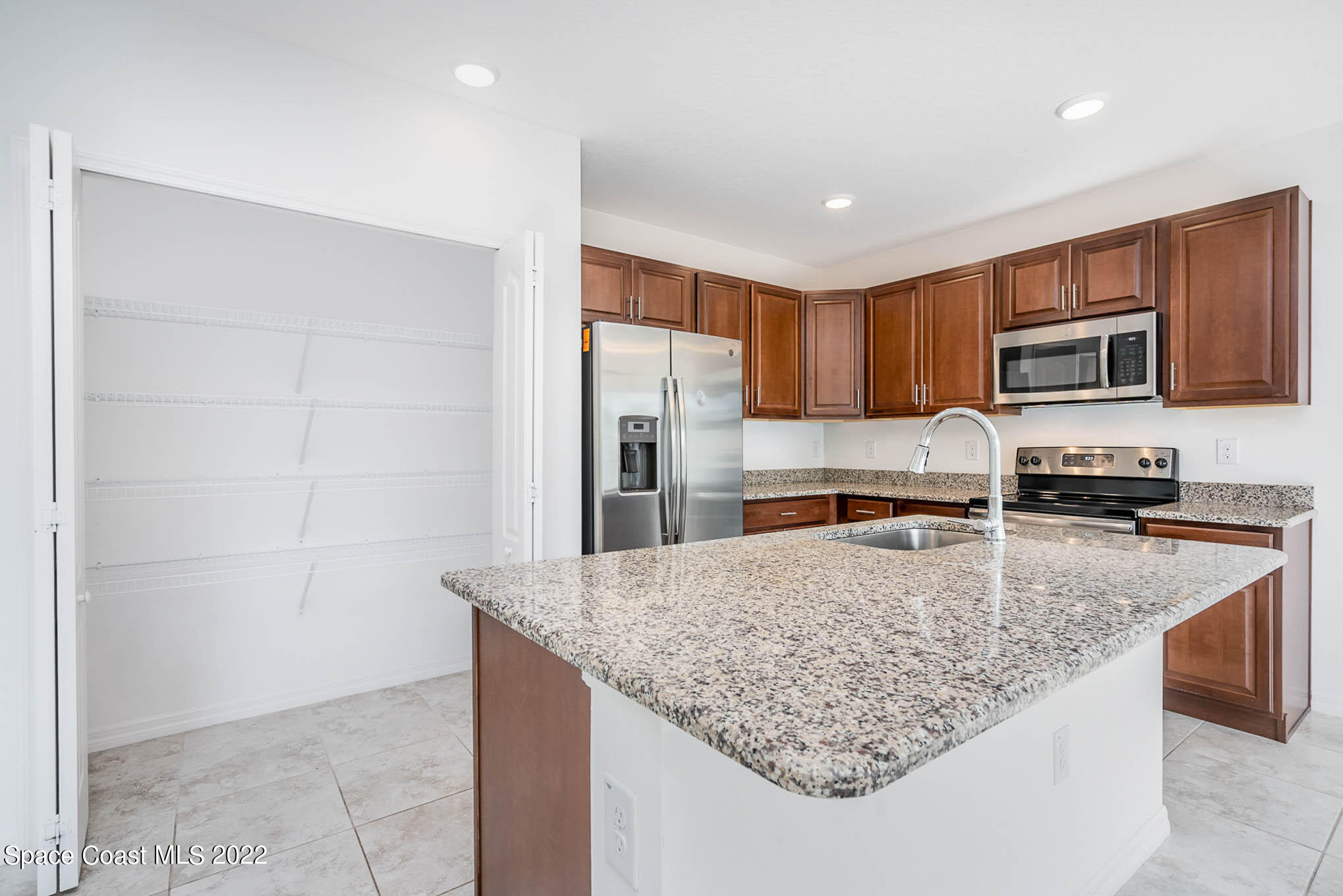 1061 Wabash Road Southeast Palm Bay, FL 32909 - Photo 6 of 22 a kitchen with kitchen island a counter top space cabinets and stainless steel appliances