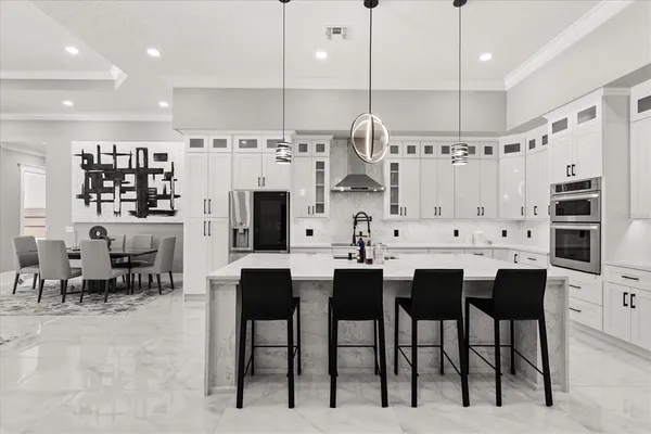 a large kitchen with stainless steel appliances a refrigerator and a stove top oven