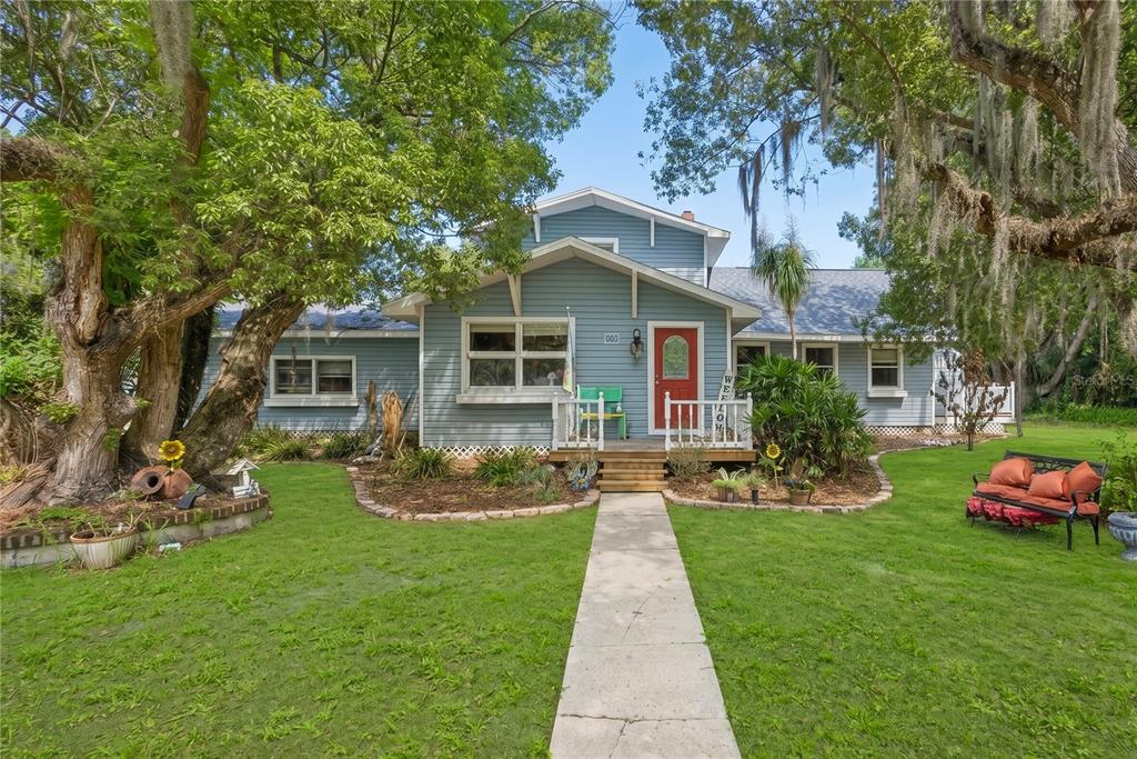1048 North Grandview Street Mount Dora, FL 32757 - Photo 1 of 56 a front view of a house with garden and trees