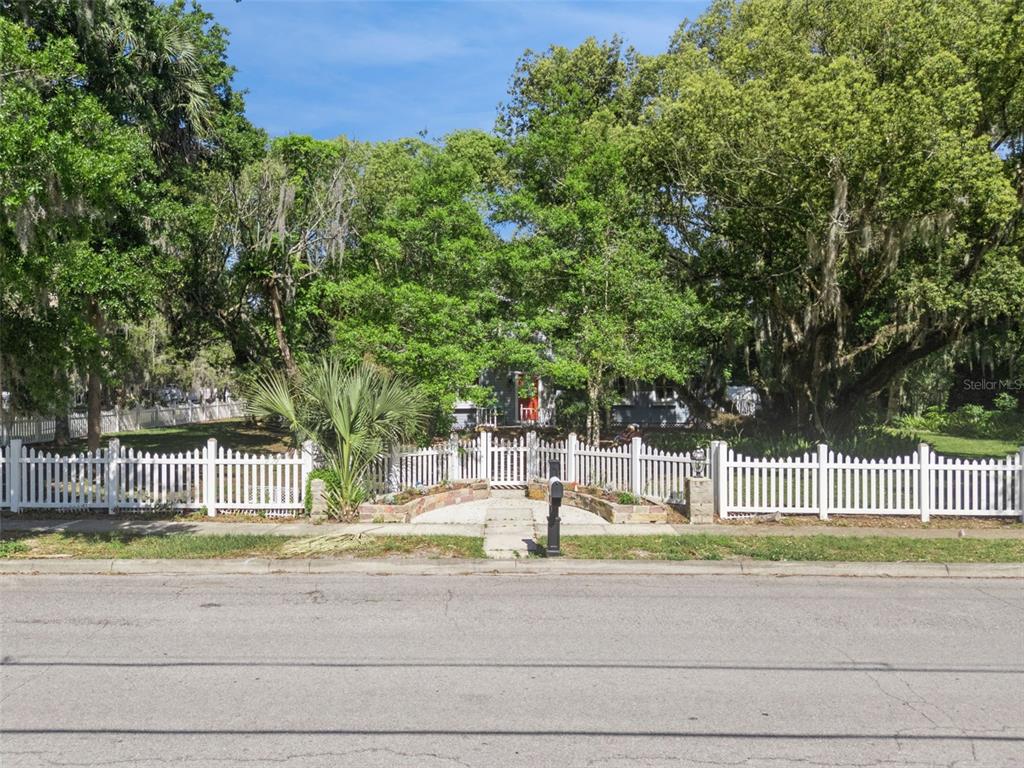 1048 North Grandview Street Mount Dora, FL 32757 - Photo 42 of 56 a view of a house with a garden and trees