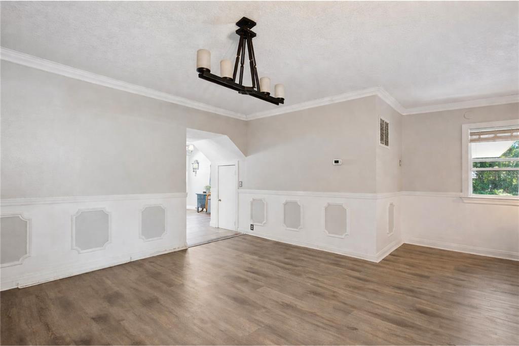 1048 North Grandview Street Mount Dora, FL 32757 - Photo 6 of 56 a view of an empty room with wooden floor and a window