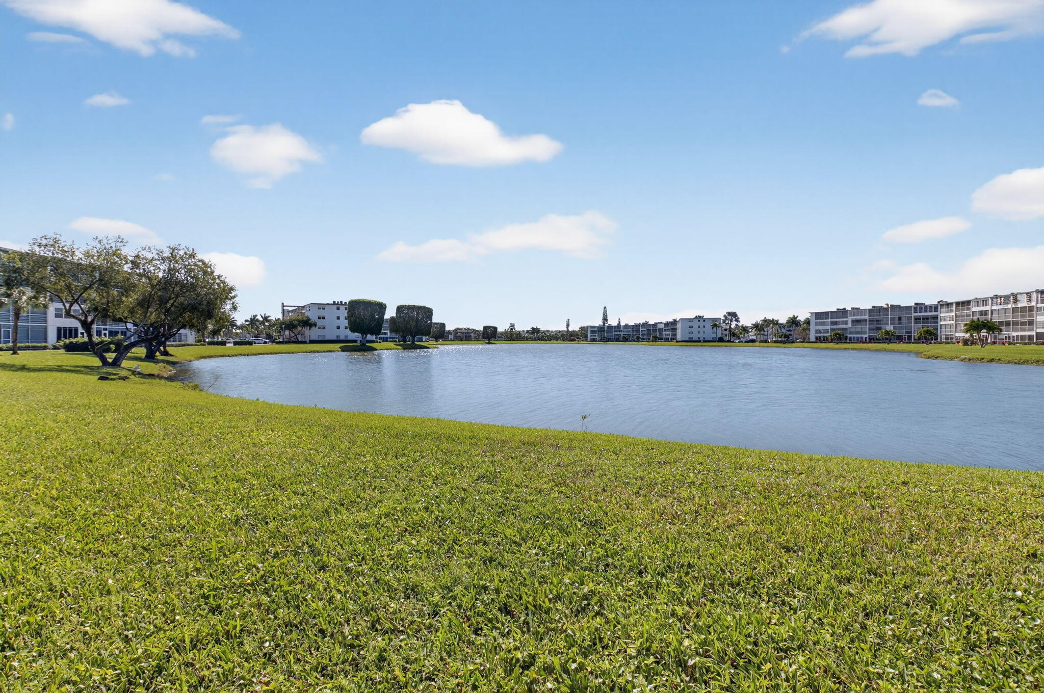 1056 Guildford East, Unit 1056 Boca Raton, FL 33434 - Photo 19 of 57 a view of a lake with houses in the back