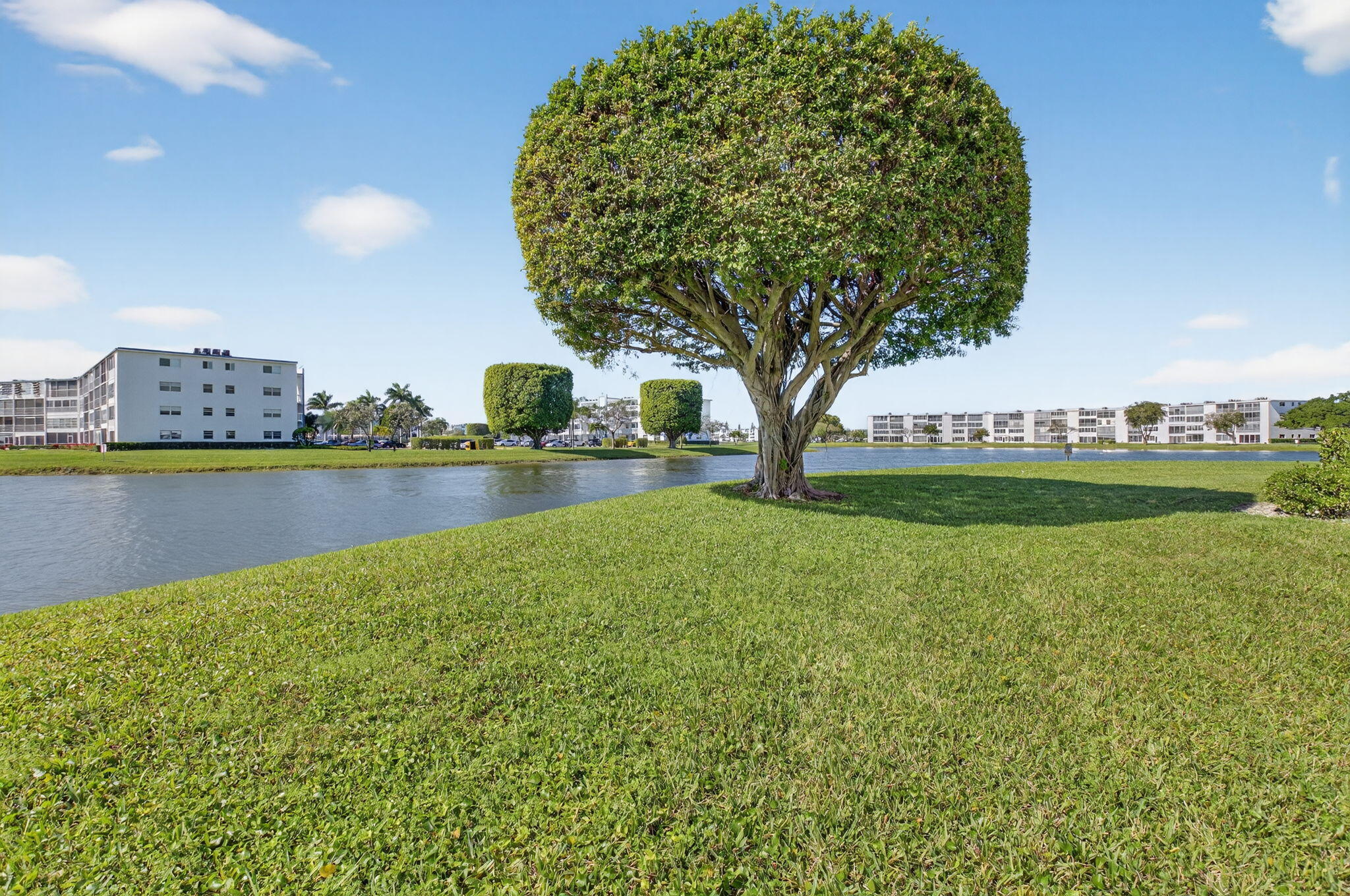 1056 Guildford East, Unit 1056 Boca Raton, FL 33434 - Photo 20 of 57 a view of a lake with a building in the background