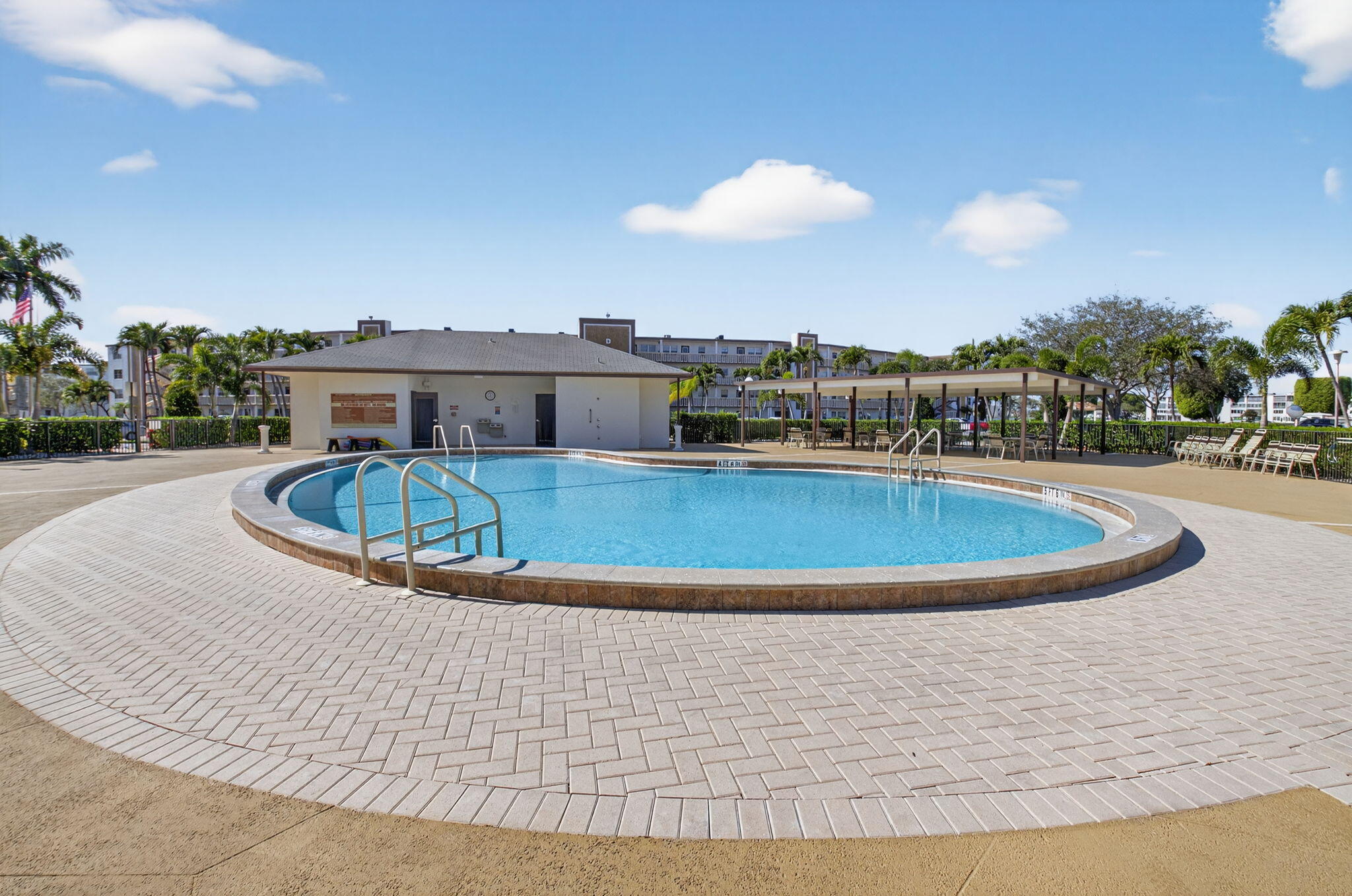 1056 Guildford East, Unit 1056 Boca Raton, FL 33434 - Photo 21 of 57 a view of a swimming pool with a table and chairs