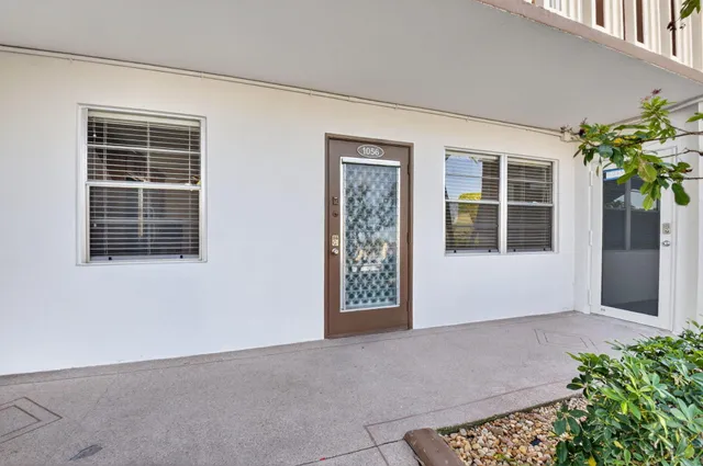 a view of an empty room with a window and potted plants
