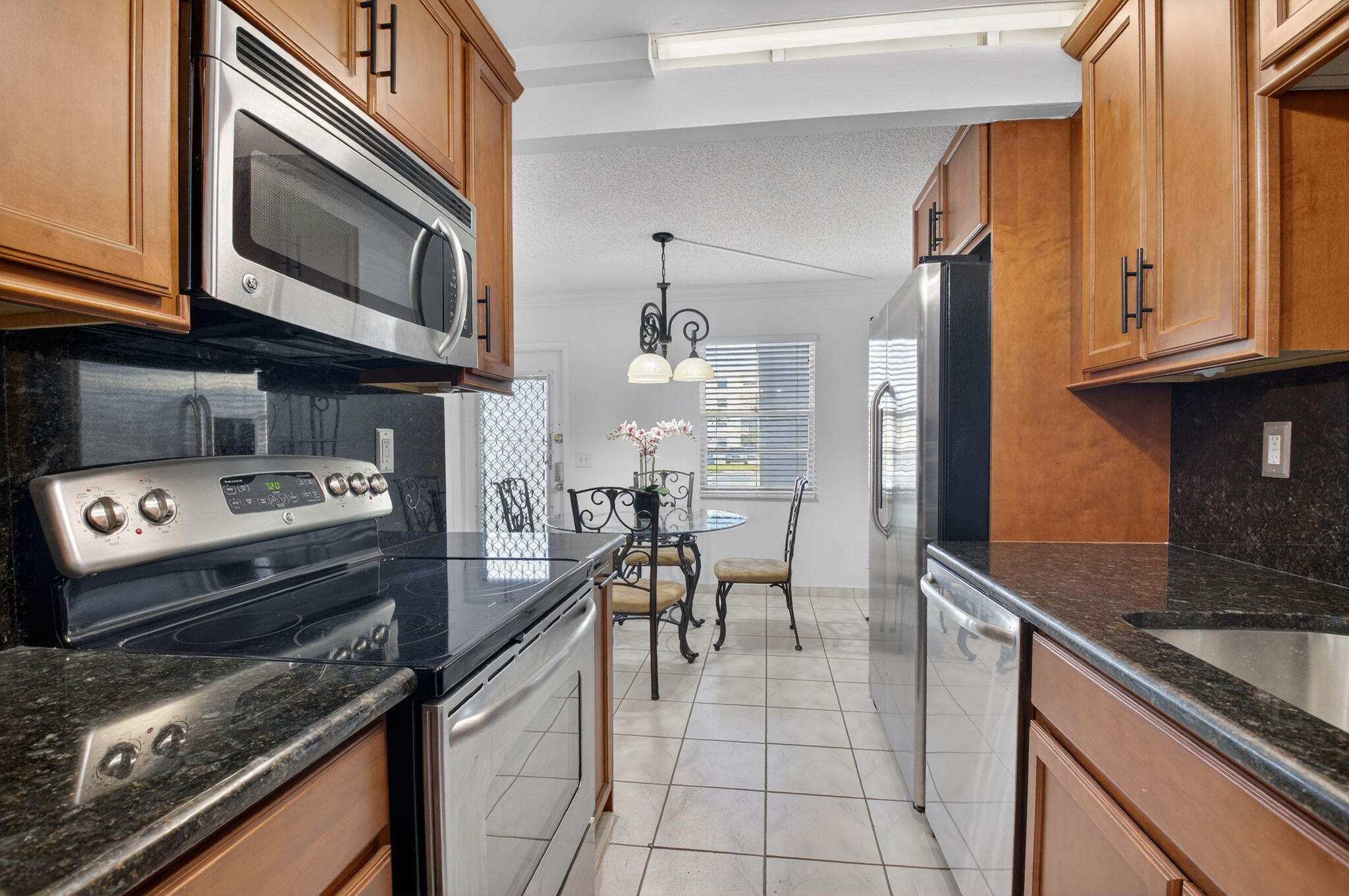 1056 Guildford East, Unit 1056 Boca Raton, FL 33434 - Photo 9 of 57 a kitchen with a stove and a microwave