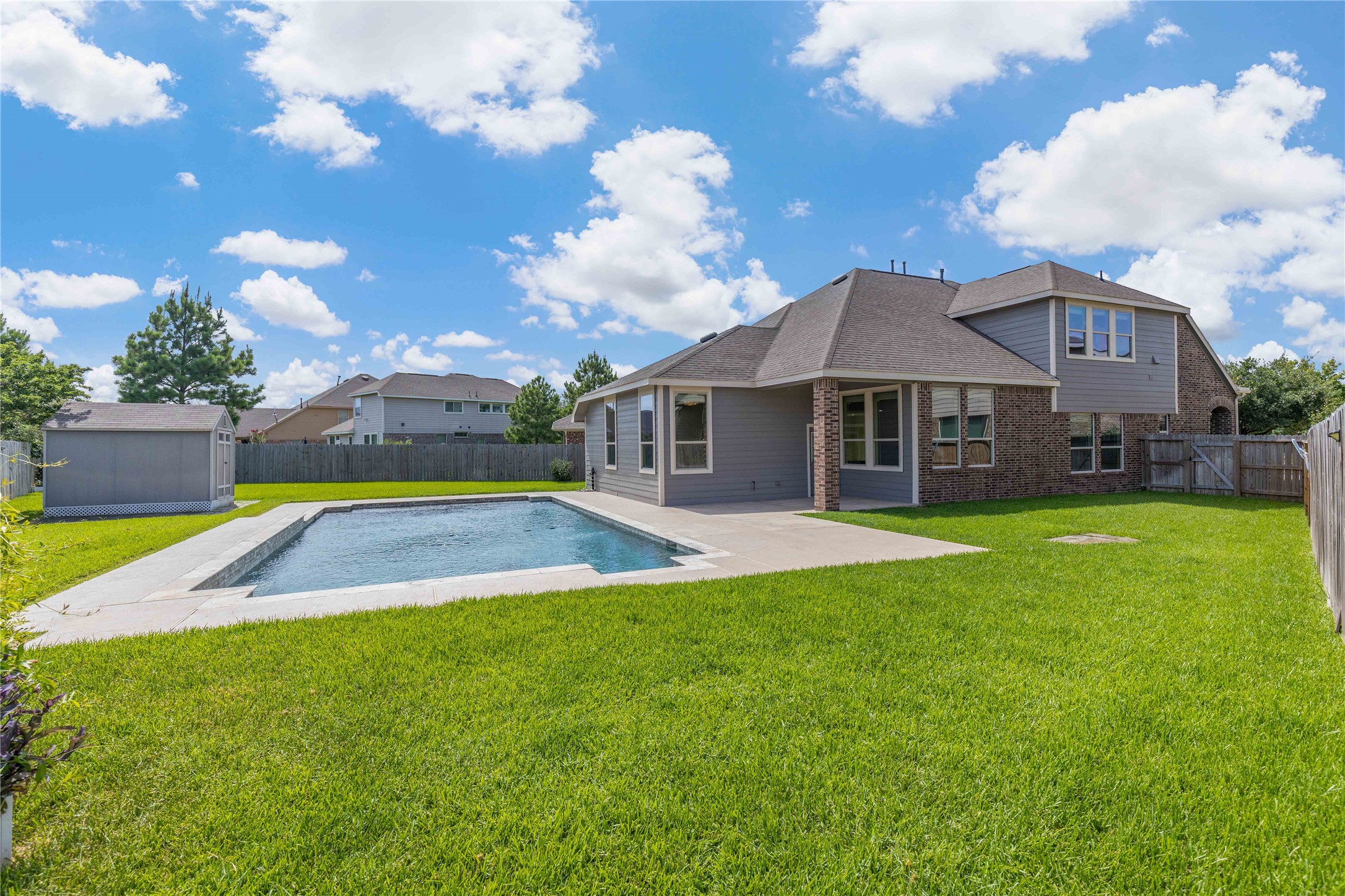 17206 Upper Ridge Lane Humble, TX 77346 - Photo 44 of 50 Spacious backyard with a well-maintained lawn, private swimming pool, and a modern two-story home. Perfect for family gatherings and outdoor relaxation.