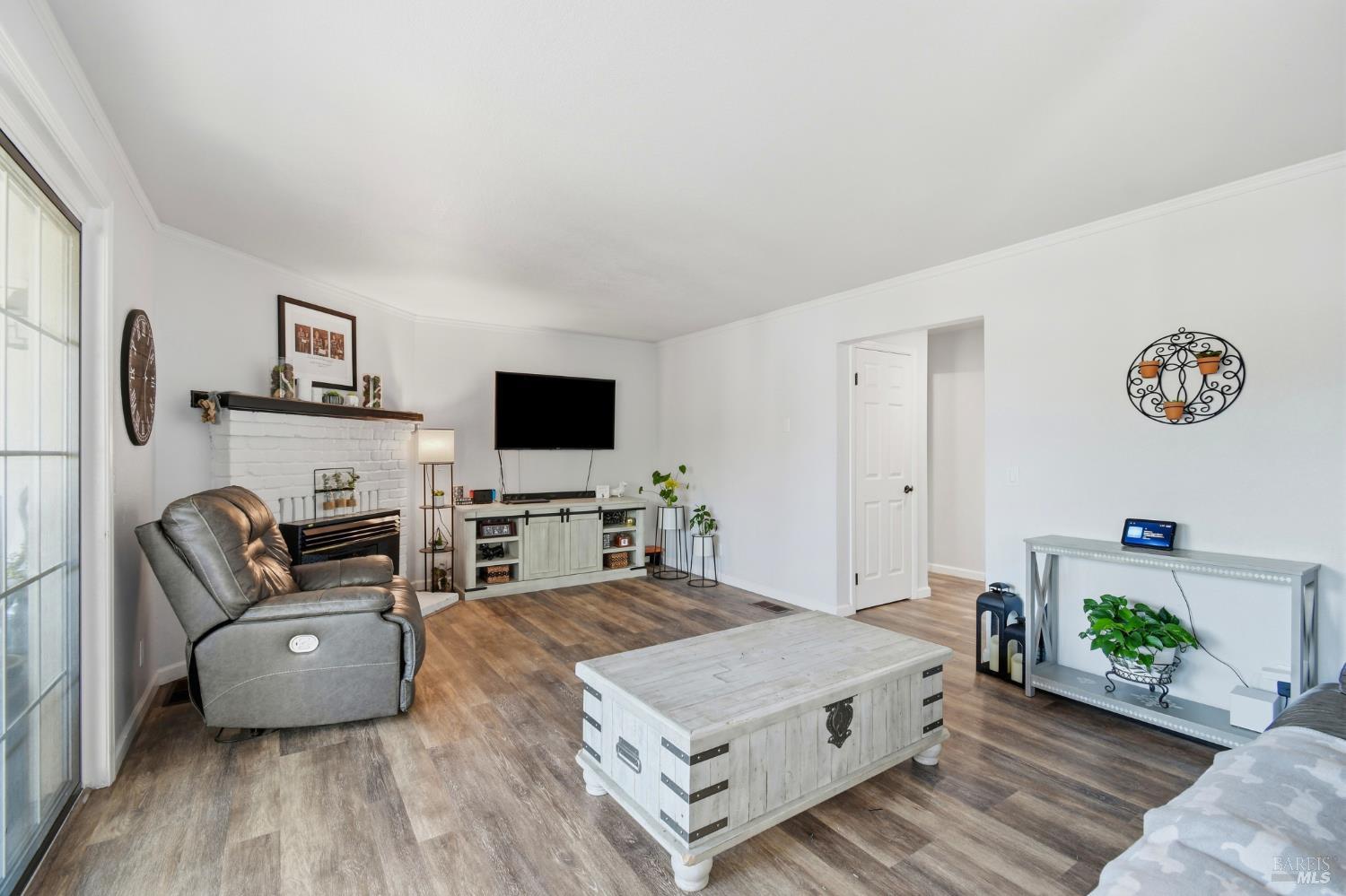 5193 Firestone Place Santa Rosa, CA 95409 - Photo 11 of 35 Spacious living room with a cozy brick fireplace, natural light, and easy deck access that's perfect for entertaining.