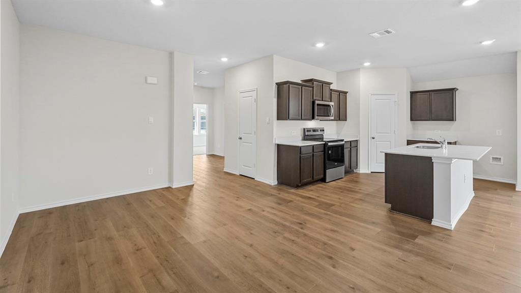1953 Freeman Street Tyler, TX 75704 - Photo 8 of 32 Spacious open-concept living area featuring wood-finish flooring, recessed lighting, and a kitchen island with a white countertop
