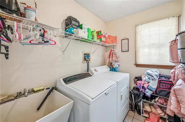 a utility room with fridge and a window