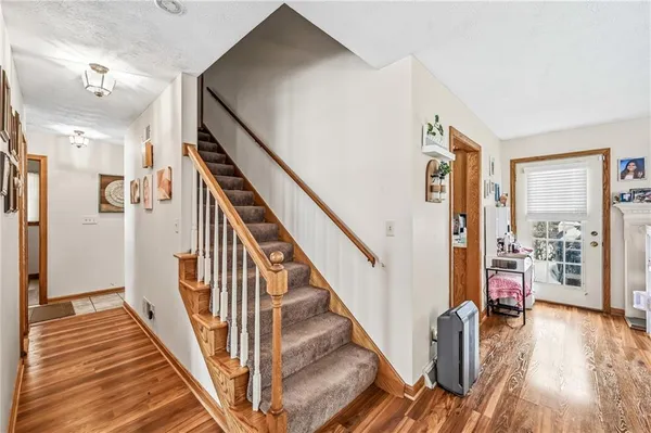 a view of a hallway with wooden floor and staircase