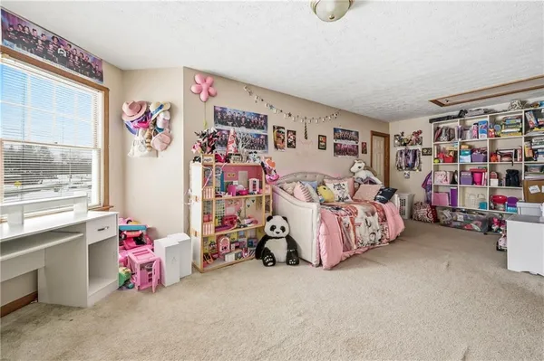 a bedroom with baby bed toys and a large window