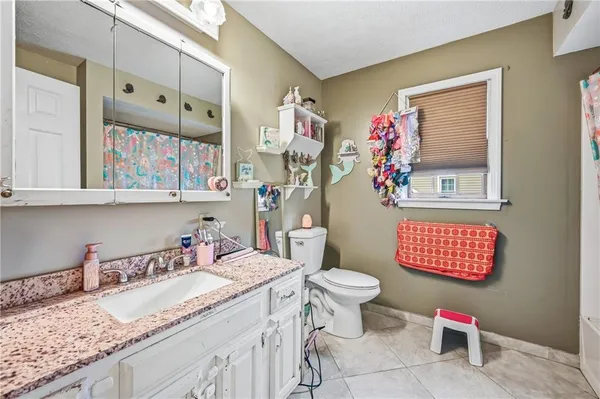 a bathroom with a granite countertop sink mirror vanity and toilet