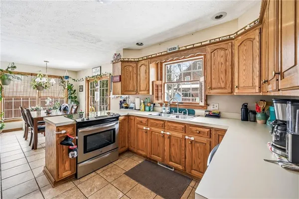 a kitchen with stainless steel appliances granite countertop a stove top oven a sink dishwasher and cabinets with wooden floor