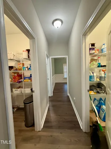 a view of a hallway with wooden floor and furniture