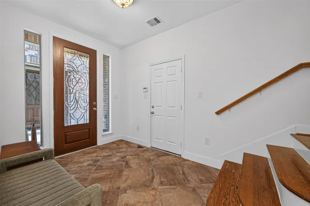 a view of an empty room with window and hallway