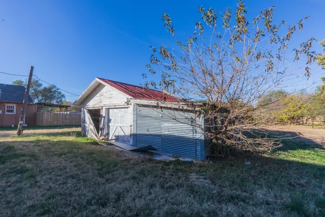 a view of a yard with plants and trees