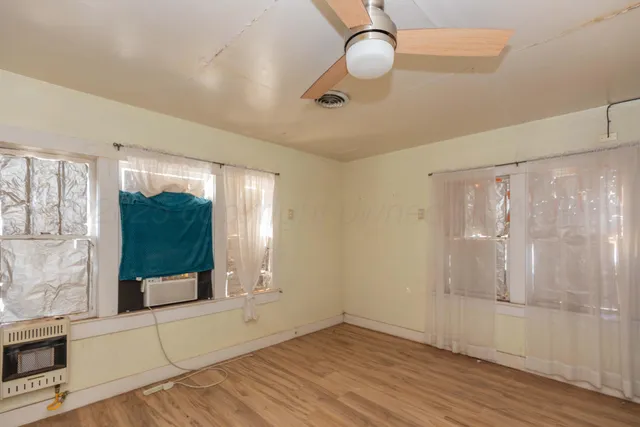 a view of a room with wooden floor and windows