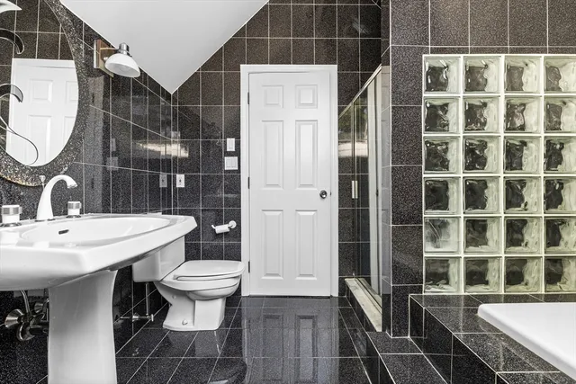 a bathroom with a sink a toilet and shower