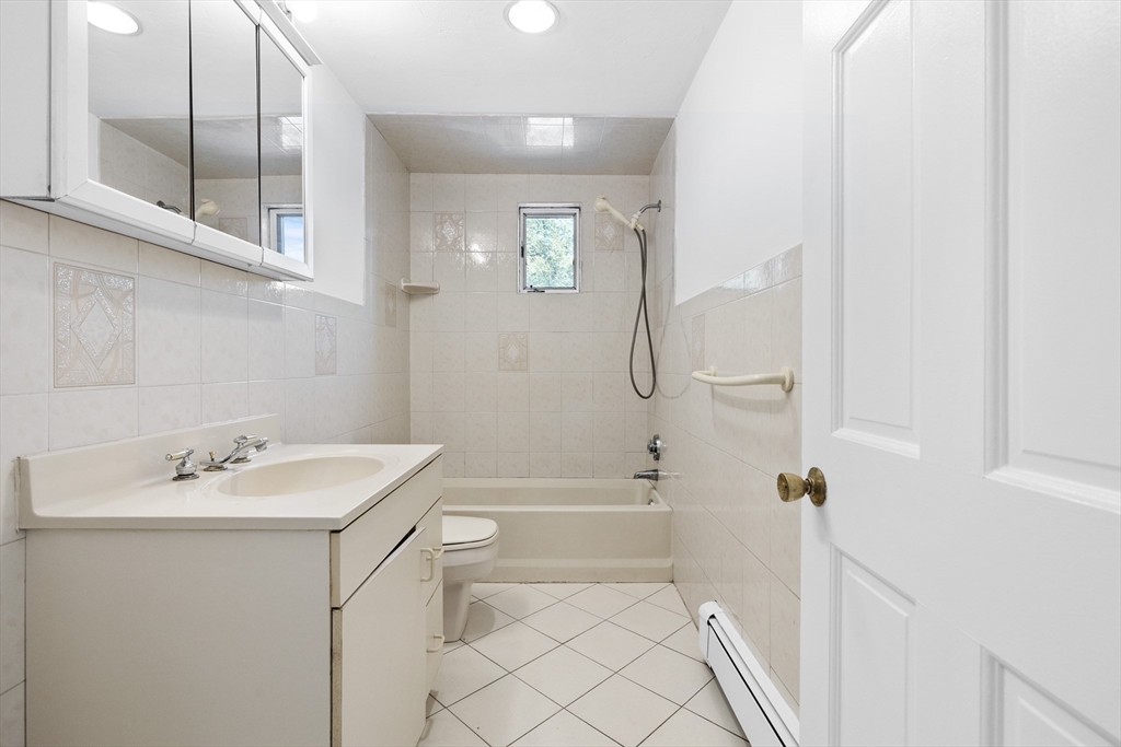 93 West R W Emerson, Unit 93R Melrose, MA 02176 - Photo 6 of 21 a bathroom with a sink a toilet and shower