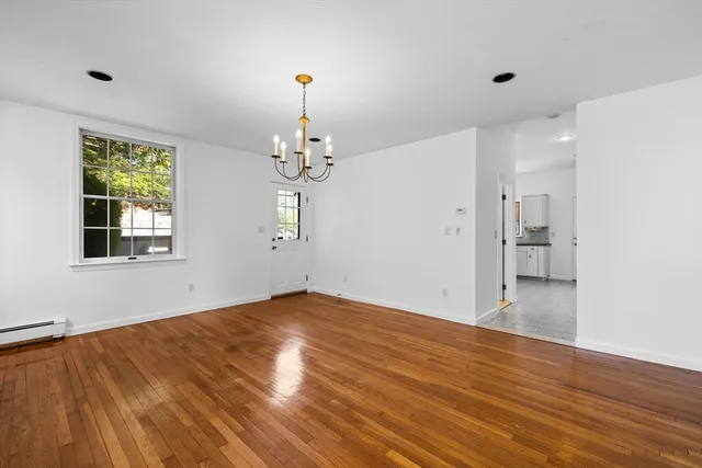 a view of empty room with wooden floor and window