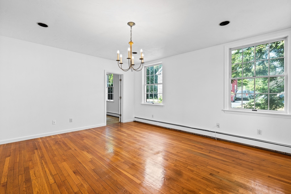 93 West R W Emerson, Unit 93R Melrose, MA 02176 - Photo 9 of 21 a view of an empty room with wooden floor and a window
