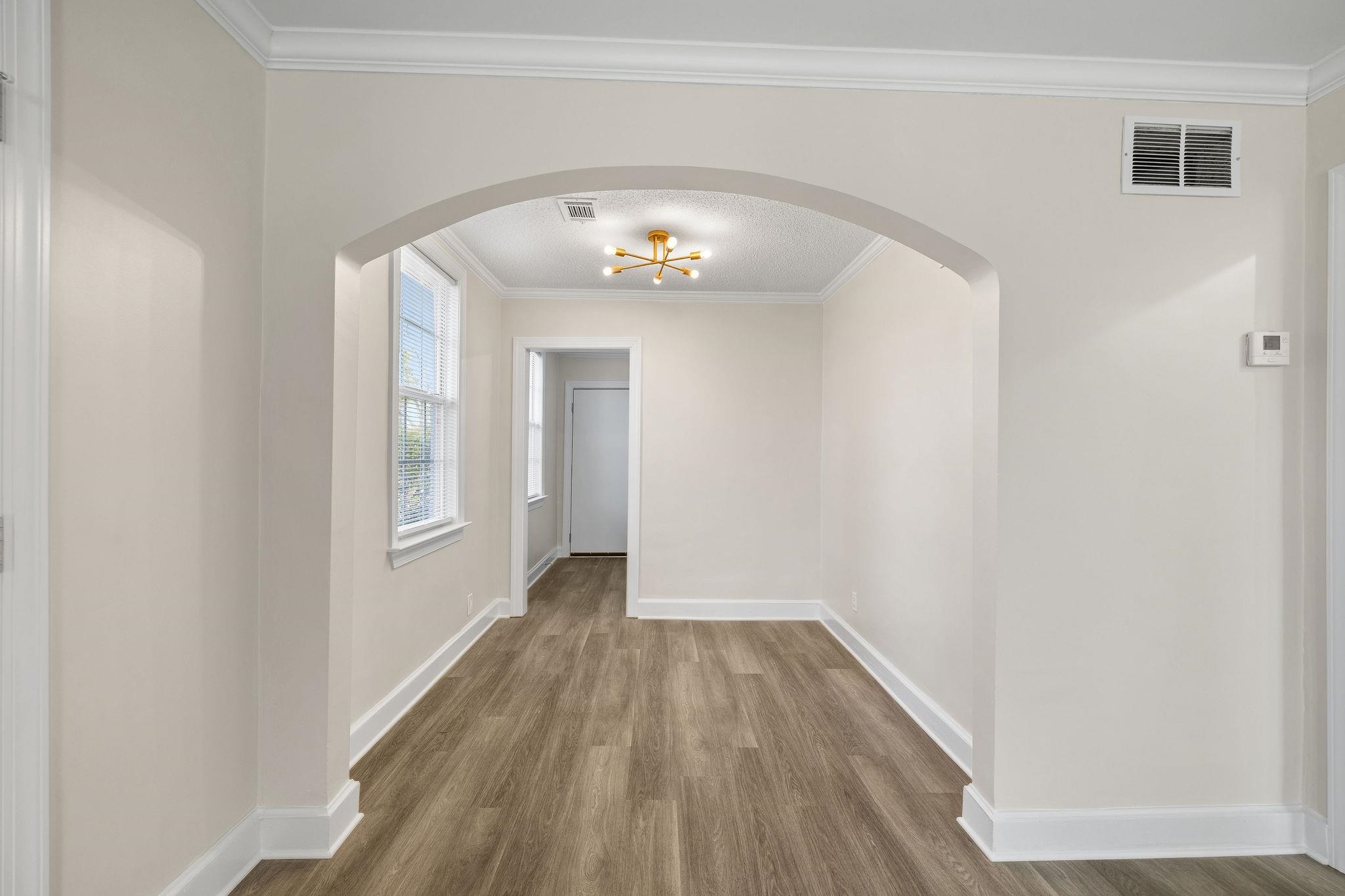 1120 Parkland Road Memphis, TN 38111 - Photo 11 of 23 Hall with ornamental molding, arched walkways, wood finished floors, and a chandelier