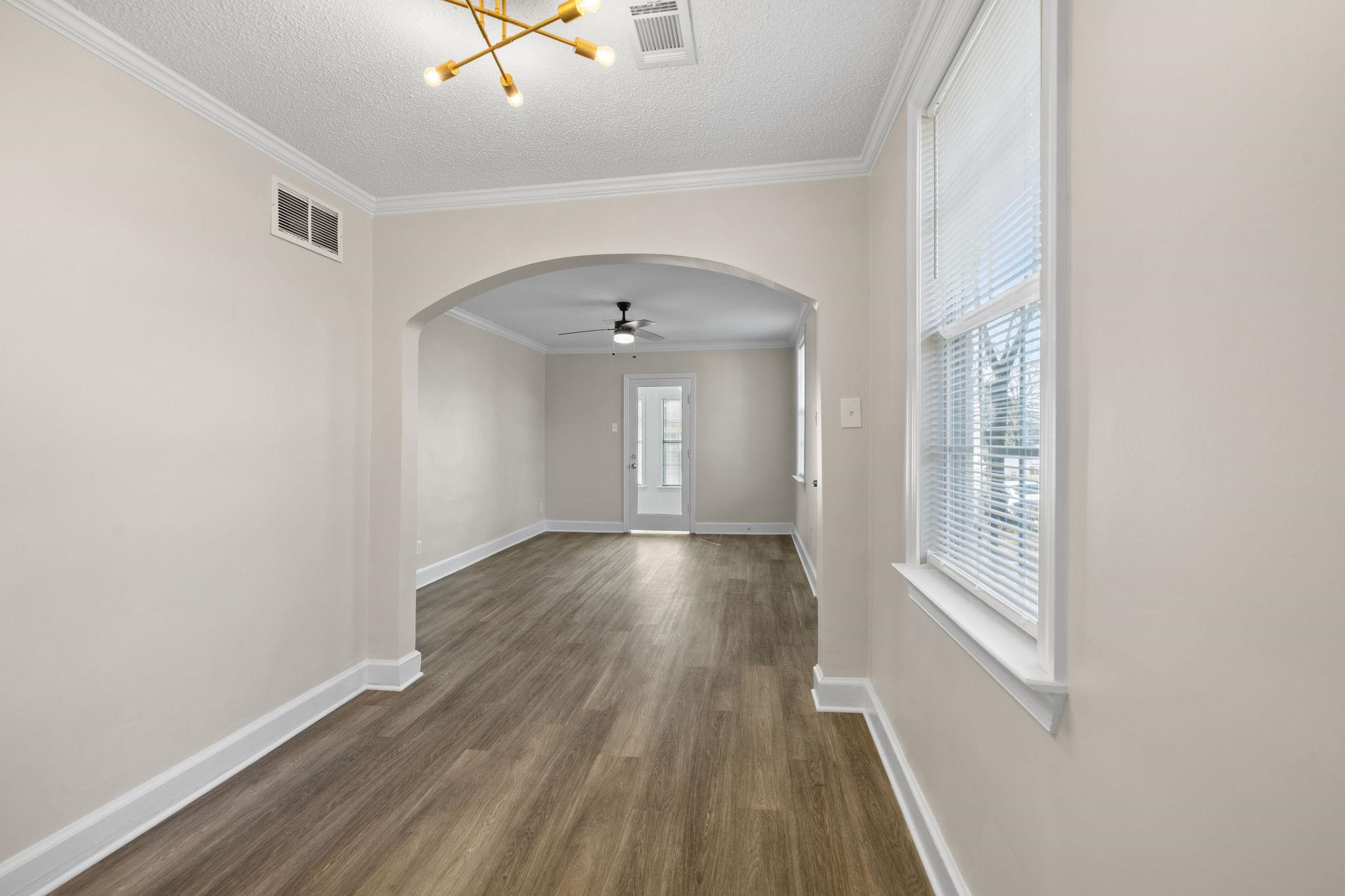 1120 Parkland Road Memphis, TN 38111 - Photo 12 of 23 Unfurnished dining area with arched walkways, ornamental molding, ceiling fan, dark wood-style floors, and a textured ceiling