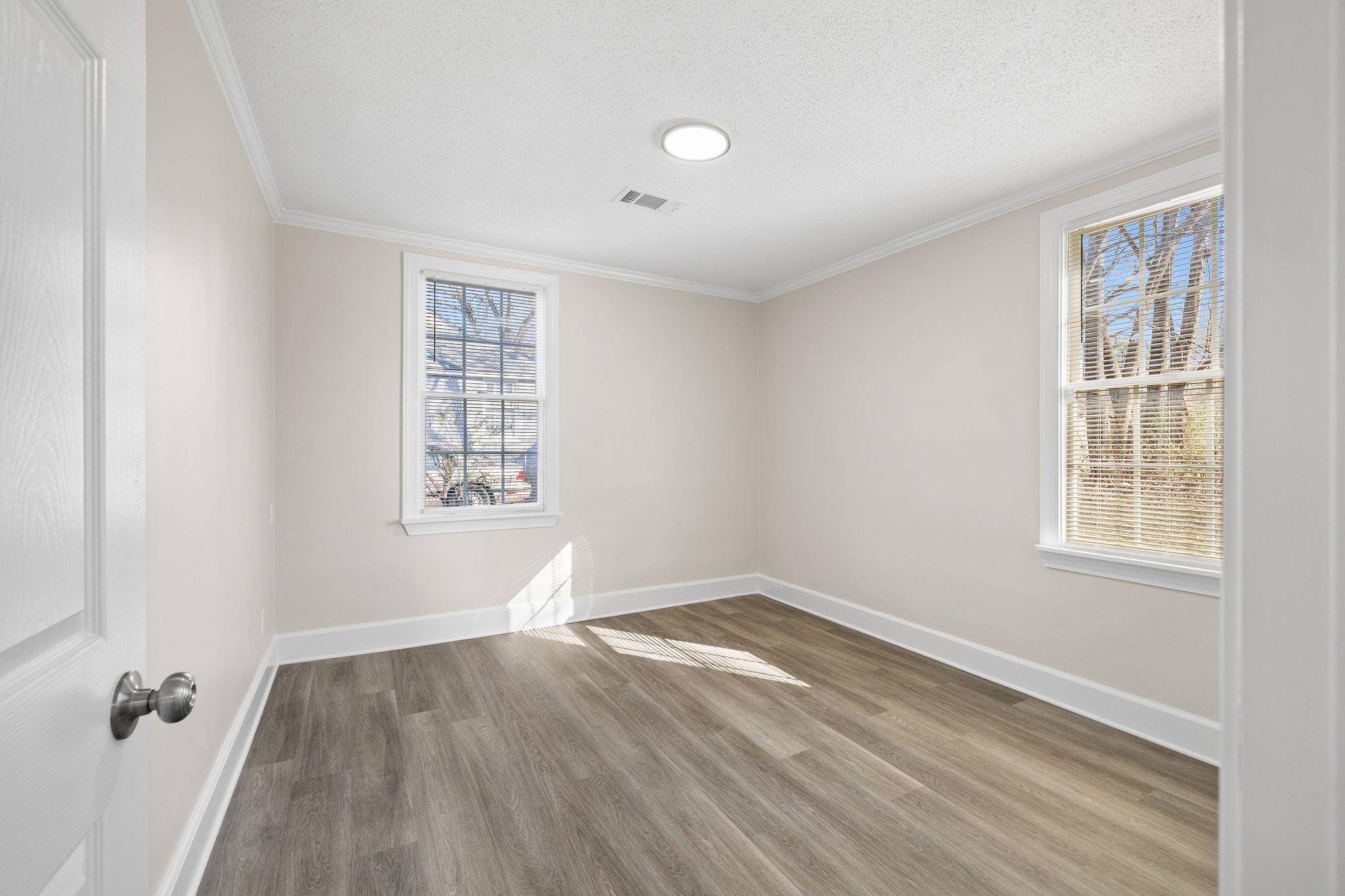 1120 Parkland Road Memphis, TN 38111 - Photo 18 of 23 Unfurnished room with light wood-style floors, crown molding, and a textured ceiling