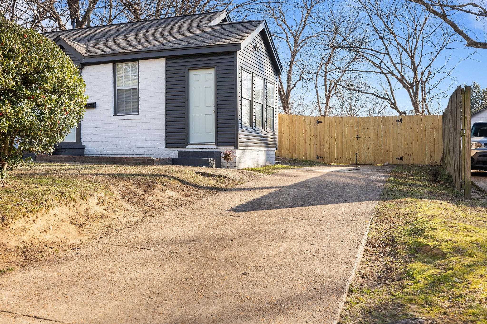 1120 Parkland Road Memphis, TN 38111 - Photo 4 of 23 View of front of house with a shingled roof, entry steps, brick siding, and concrete driveway