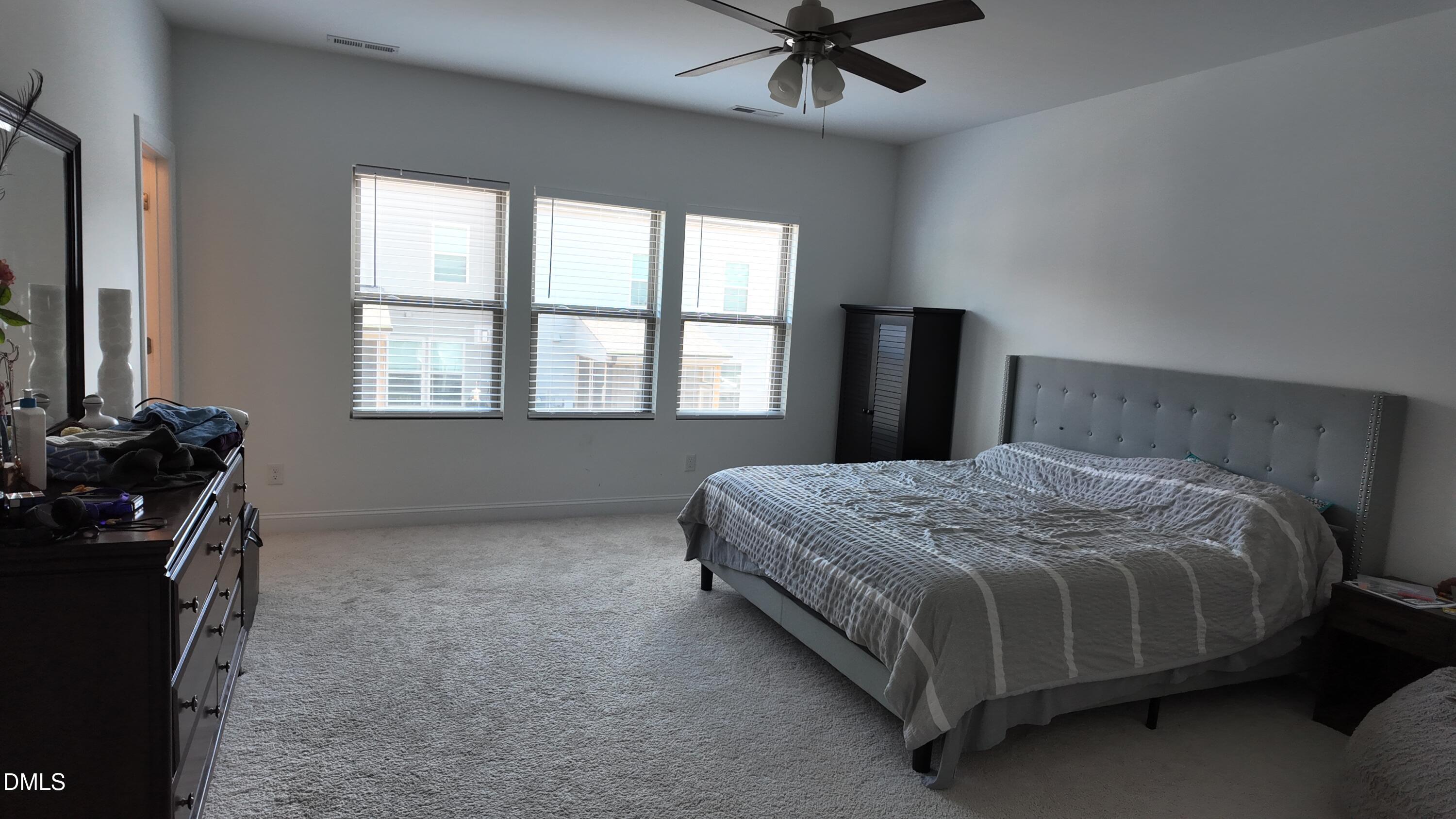 2143 Stegemann Street Apex, NC 27502 - Photo 21 of 39 a bedroom with a bed dresser and a flat tv screen