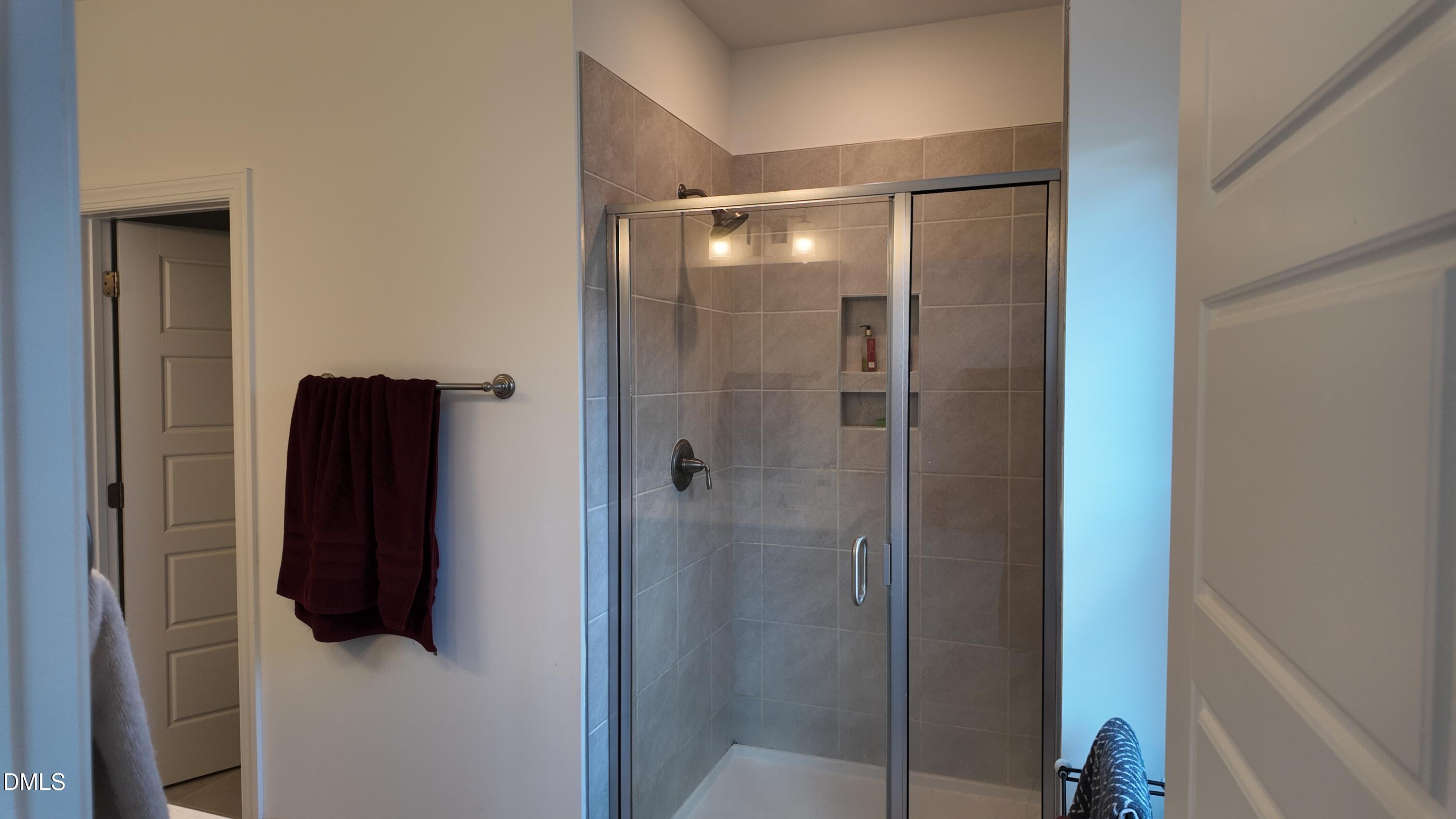 2143 Stegemann Street Apex, NC 27502 - Photo 22 of 39 a bathroom with a glass shower door