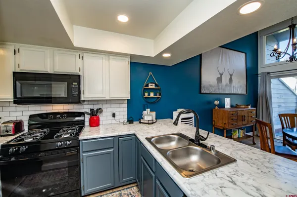 a kitchen with stainless steel appliances granite countertop a sink stove top oven and refrigerator
